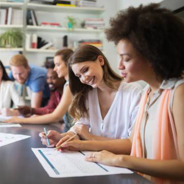 Casually dressed people reviewing work and engaging with each other at a table