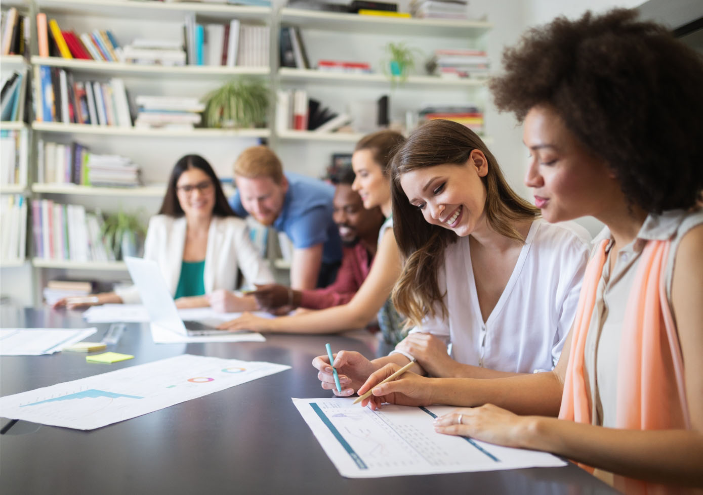 Casually dressed people reviewing work and engaging with each other at a table